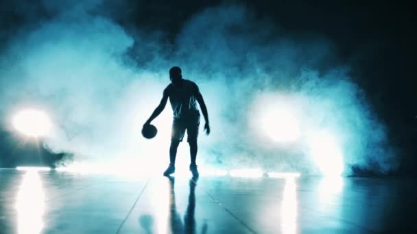 Quarto escuro com nuvens de fumaça e um homem jogando uma bola de basquete — Vídeo de Stock
