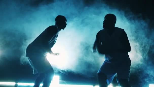 Dois jogadores de basquete estão praticando em uma sala escura — Vídeo de Stock
