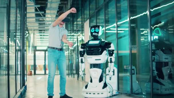 Un bărbat comunică cu un robot prin intermediul ochelarilor VR — Videoclip de stoc