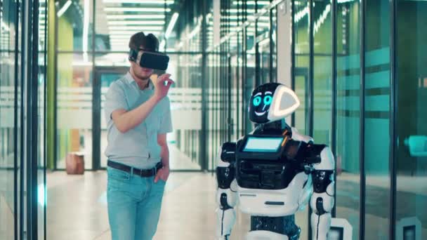 Концепция коммуникации человека и робота. Бизнесмен носит очки VR и общается с роботом — стоковое видео