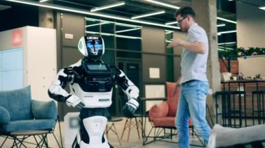 Adamın biri bir sayborgun yanında robot dansı yapıyor. Yapay zeka, robotik yenilik, cyborg konsepti.