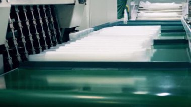 Birçok plastik bardağı saran fabrika işçisi.
