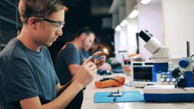 Erkek uzman bir cep telefonunun devrelerini inceliyor