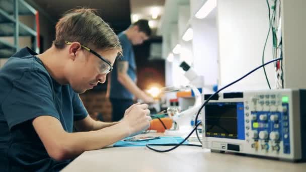 Especialista masculino está reparando um telefone celular — Vídeo de Stock