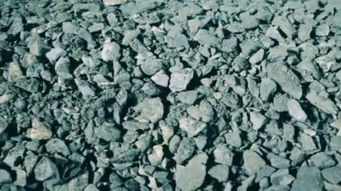 Taşıyıcı boyunca hareket eden bir sürü gri mineral var.