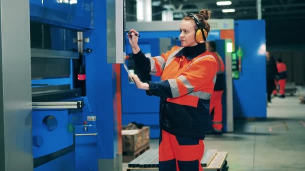 Female worker using touchscreen with a stylus at a modern factory. — Stock Video