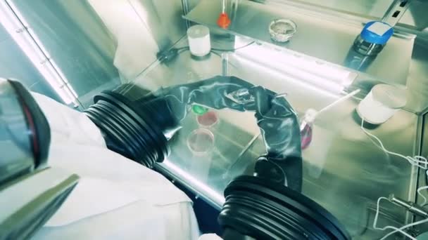 A specialist in a hazmat suit is researching probes in a vacuum cabinet — Stock Video