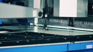 Büyük metal plaka bir fabrikada otomatik bir makine tarafından bükülüyor.