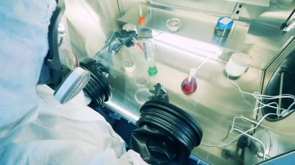 Travailleur de laboratoire dans une combinaison Hazmat exploite une armoire de laboratoire — Video