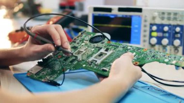 Elements of a circuit are getting inspected by a specialist