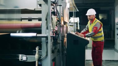 Mühendislik uzmanı büyük bir makine kompleksi çalıştırıyor.