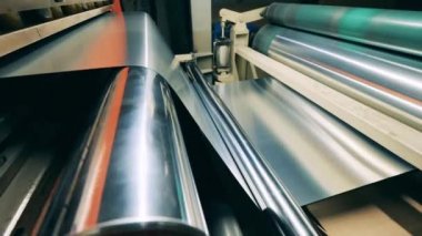 Metal levha, dönen taşıyıcıdan geçiyor.