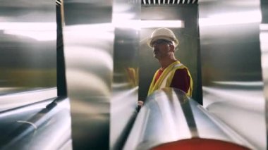 Mühendislik uzmanı metal malzemelerini inceliyor.