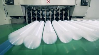 Plastik bardaklı taşıyıcı bant onunla taşınıyor.