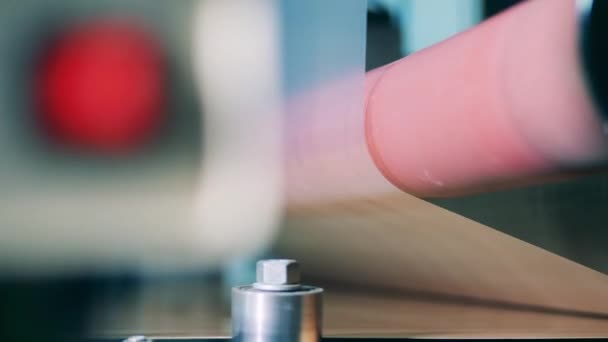 Carretel giratório com enrolamento de material metálico transparente ao longo dele — Vídeo de Stock