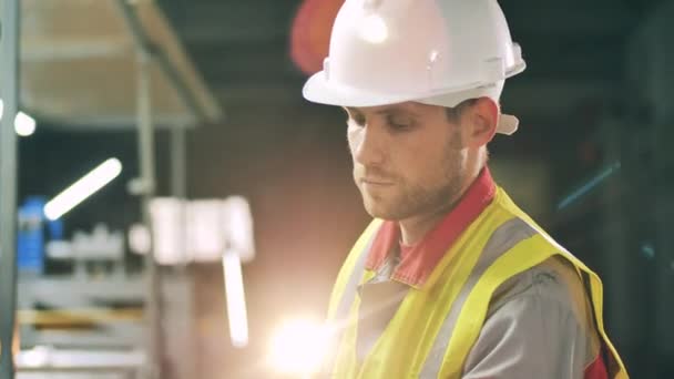 Gyári egység férfi mérnökkel keménykalapban és biztonsági mellényben — Stock videók