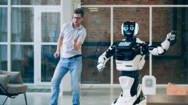 İnsan ve robot iletişim konsepti. İş adamı ve bir cyborg birlikte dans ediyorlar.