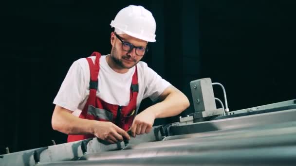 El hombre de mantenimiento está ajustando los elementos de un transportador rodante — Vídeos de Stock