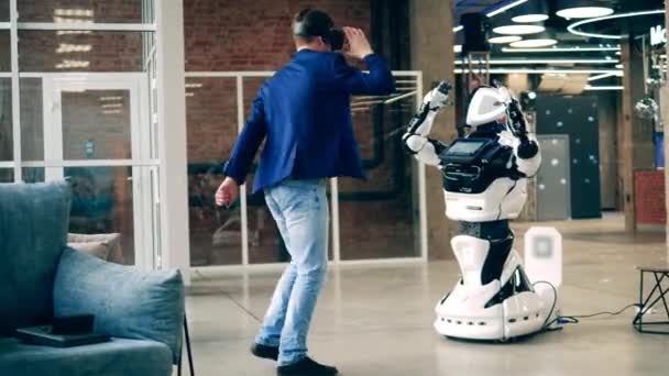 Концепция коммуникации человека и робота. Киборг и бизнесмен танцуют в зале — стоковое видео