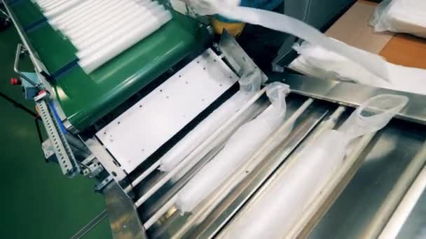 Lotes de vasos de plástico en polietileno se están poniendo en el transportador — Vídeos de Stock