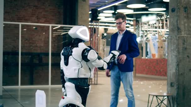 Affärsman har kontakt med en modern robot. Koncept för kommunikation mellan människa och robot. — Stockvideo