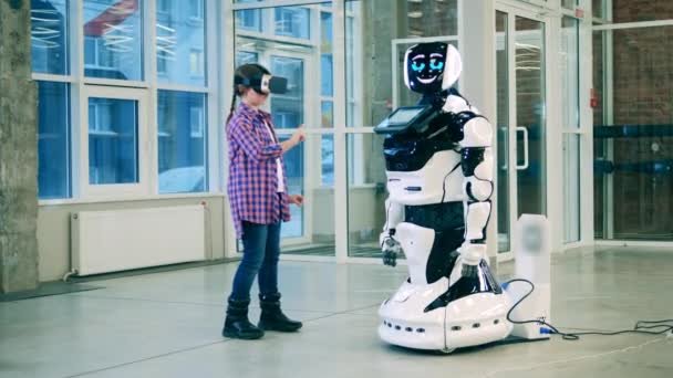Robot moderne discute avec une fille portant des lunettes VR — Video