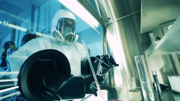 A specialist is working with test tubes inside of a vacuum cabinet — Stock Video