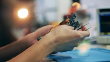 Parçalanmış bir aletin elementleri bir tamircinin elinde.