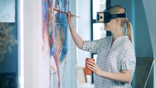 Blond woman wearing VR-device is painting a picture — Stock Video