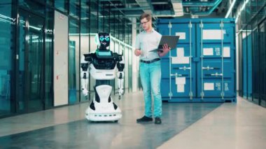 Gelecek, yenilik, bilim, robot konsepti. Geleceğin hizmetkar robotu, erkek bir uzmanla iletişim kuruyor.