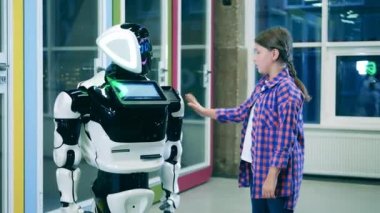 Küçük bir kız gelecekçi bir robotla iletişim kuruyor. Gelecekçi teknoloji konsepti.