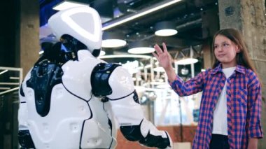 Geleceğin robotu bir kızla el ele tutuşuyor. Gelecek, yenilik, bilim, robot kavramı.