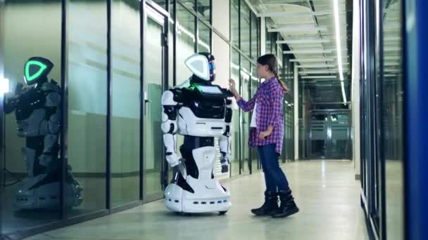 A tinédzser lány megérint egy emberszerű robotot. — Stock videók