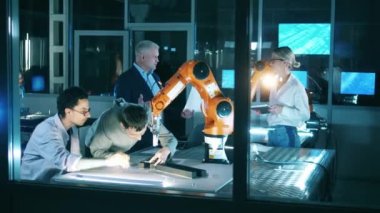 Bir grup bilim adamı bir robot laboratuvarında birlikte çalışıyorlar.