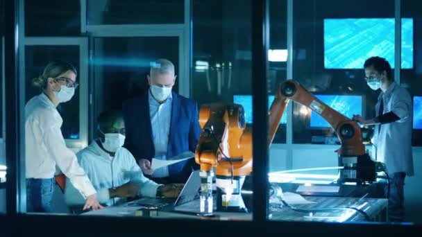 Professionele ingenieurs werken met innovatieve apparatuur, teamwork concept. Wetenschappers met gezichtsmaskers bestuderen robots in het laboratorium. — Stockvideo