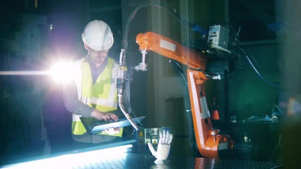 Serviceman inspecte un appareil robotique dans le laboratoire — Video