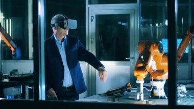 Erkek araştırmacı sanal gerçeklikte bir robot mekanizması çalıştırıyor.