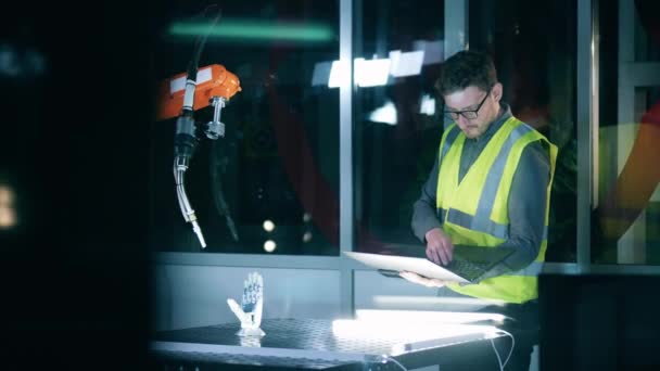 Maintenance man is studying a robotic mechanism — Stock Video