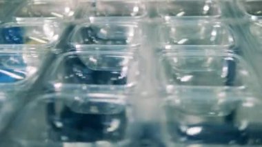 Plastik üretim, polimer geri dönüşüm fabrikası. Yakın planda şeffaf plastik konteynır üretim hattı