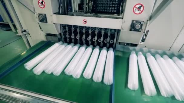 Copos de plástico sendo colocados automaticamente em um transportador — Vídeo de Stock