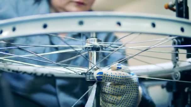 Fiets monteur rijgen een velg bij een fiets fabriek — Stockvideo