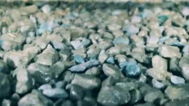 Parçalanmış mineraller taşıyıcı boyunca hareket ederken titriyor.