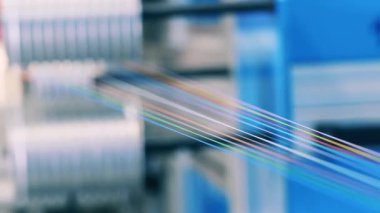 Küçük renkli elektrik kabloları makaradan sökülüyor. Kapat.