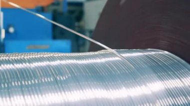 Gümüş tel büyük bir makaradan sökülüyor.