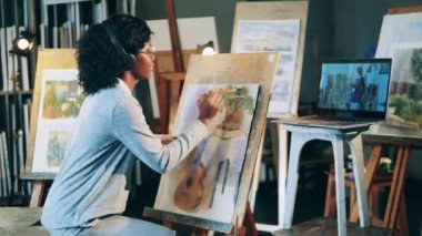 Afrikalı etnik kadın video dersi alırken resim yapıyor.