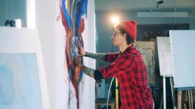 Resim, çıplak elleriyle dövmeli bir adam tarafından çiziliyor. Yaratılış, ilham kavramı.