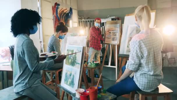 Kreatywne hobby, koncepcja dzieła sztuki. Grupa kobiet w maskach ma lekcję malowania. — Wideo stockowe