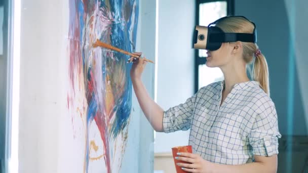 Femme blonde utilise un pinceau et VR-lunettes pour la peinture — Video