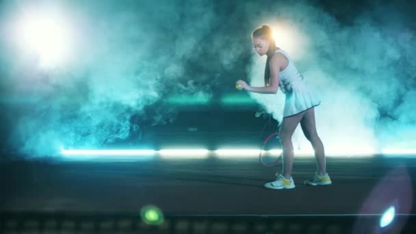 Mujer atlética está lanzando una pelota de tenis con una raqueta — Vídeos de Stock