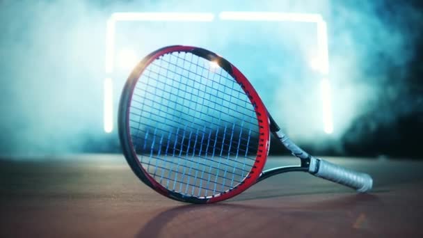 Raquette de tennis est couché sur le sol dans une salle sombre — Video